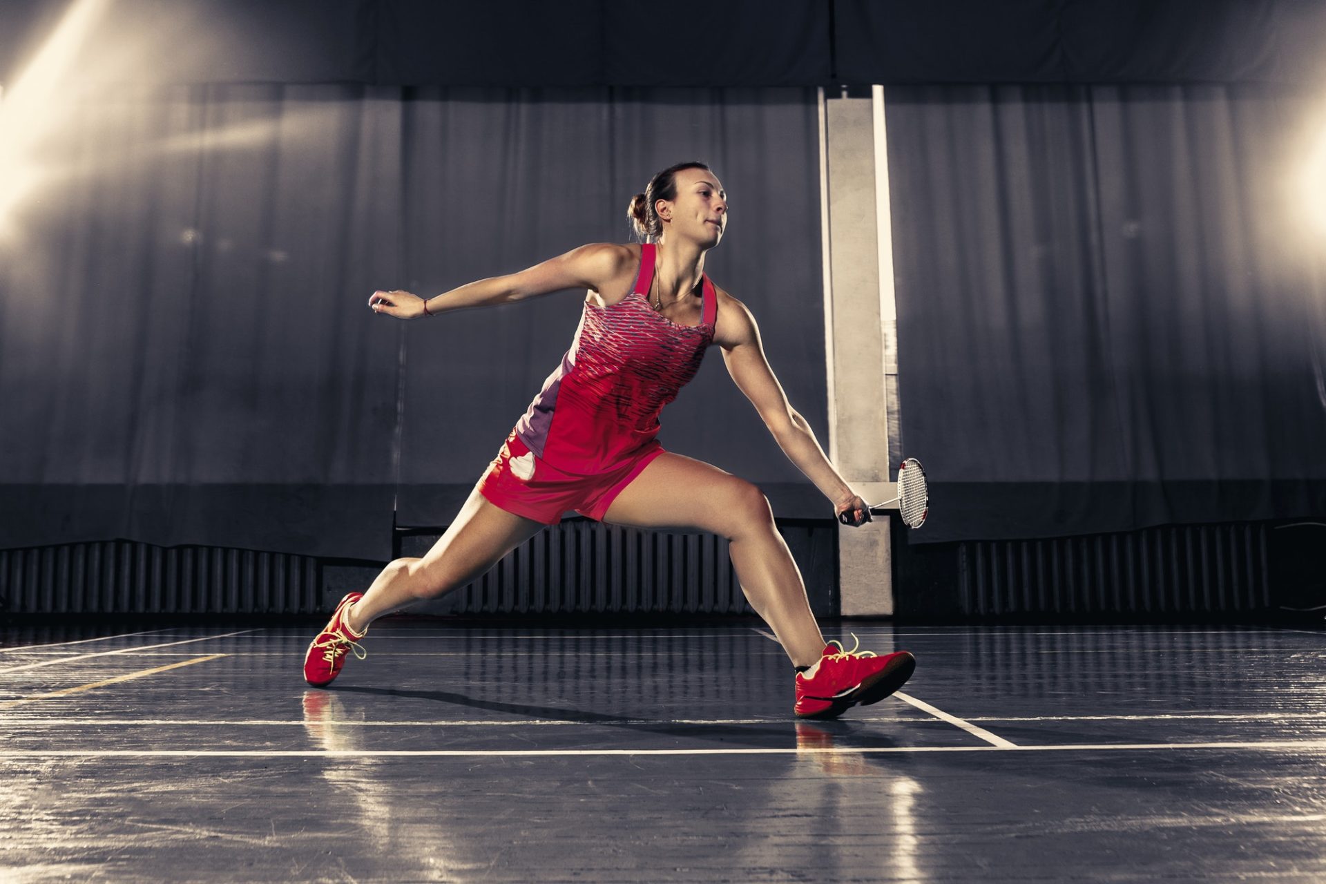 young-woman-playing-badminton-at-gym-e1657617468257.jpg