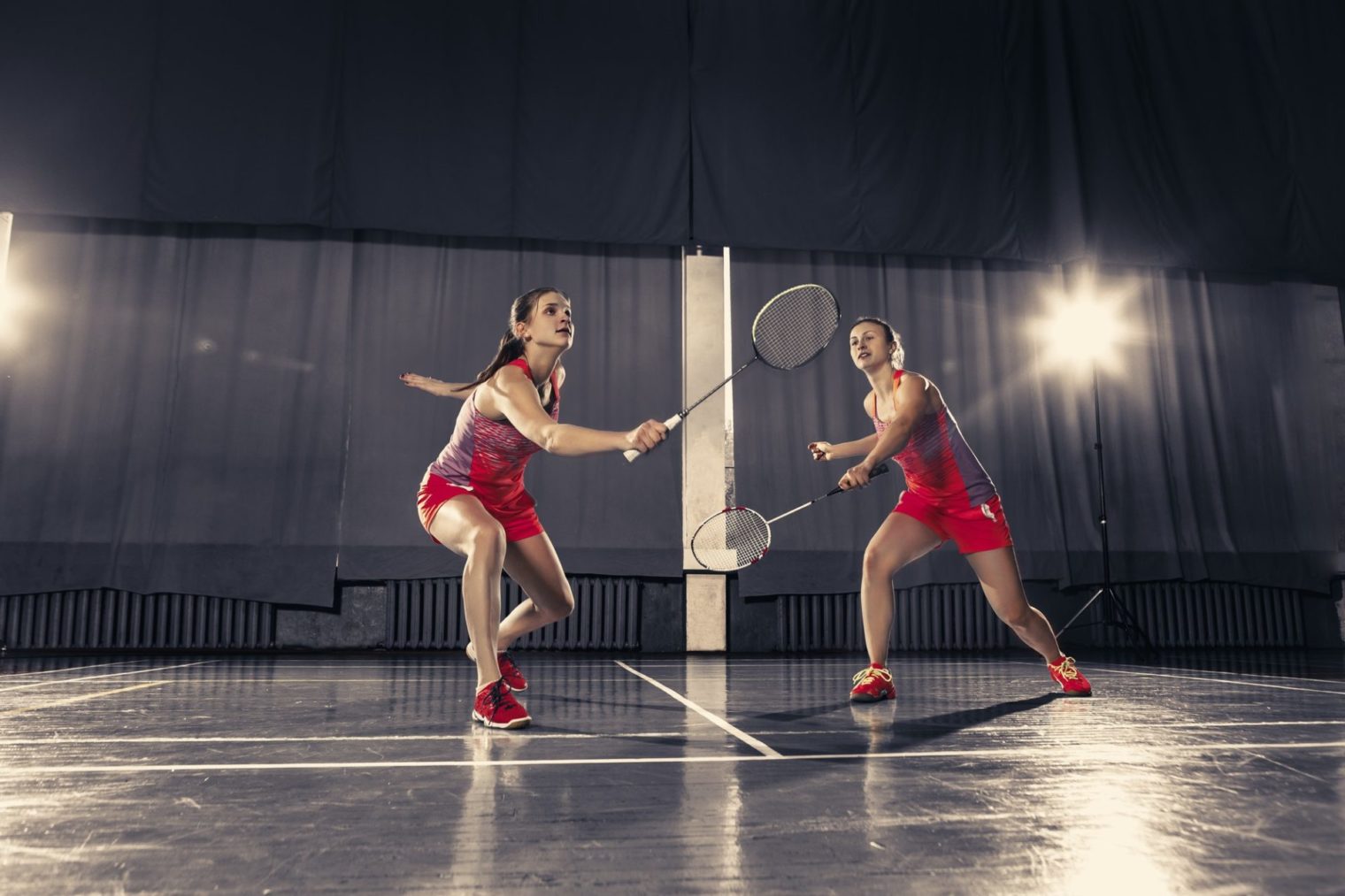 young-women-playing-badminton-at-gym-e1657184708714.jpg